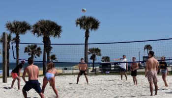 Spring breakers play volleyball during a spring break at...