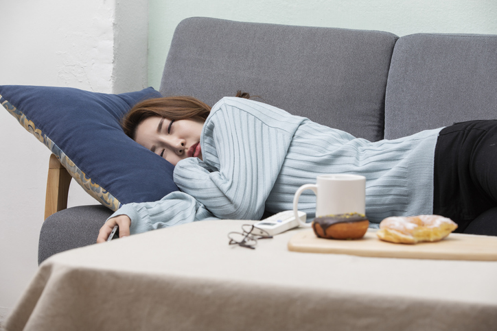 Asian Woman Drinking Coffe and Watching TV
